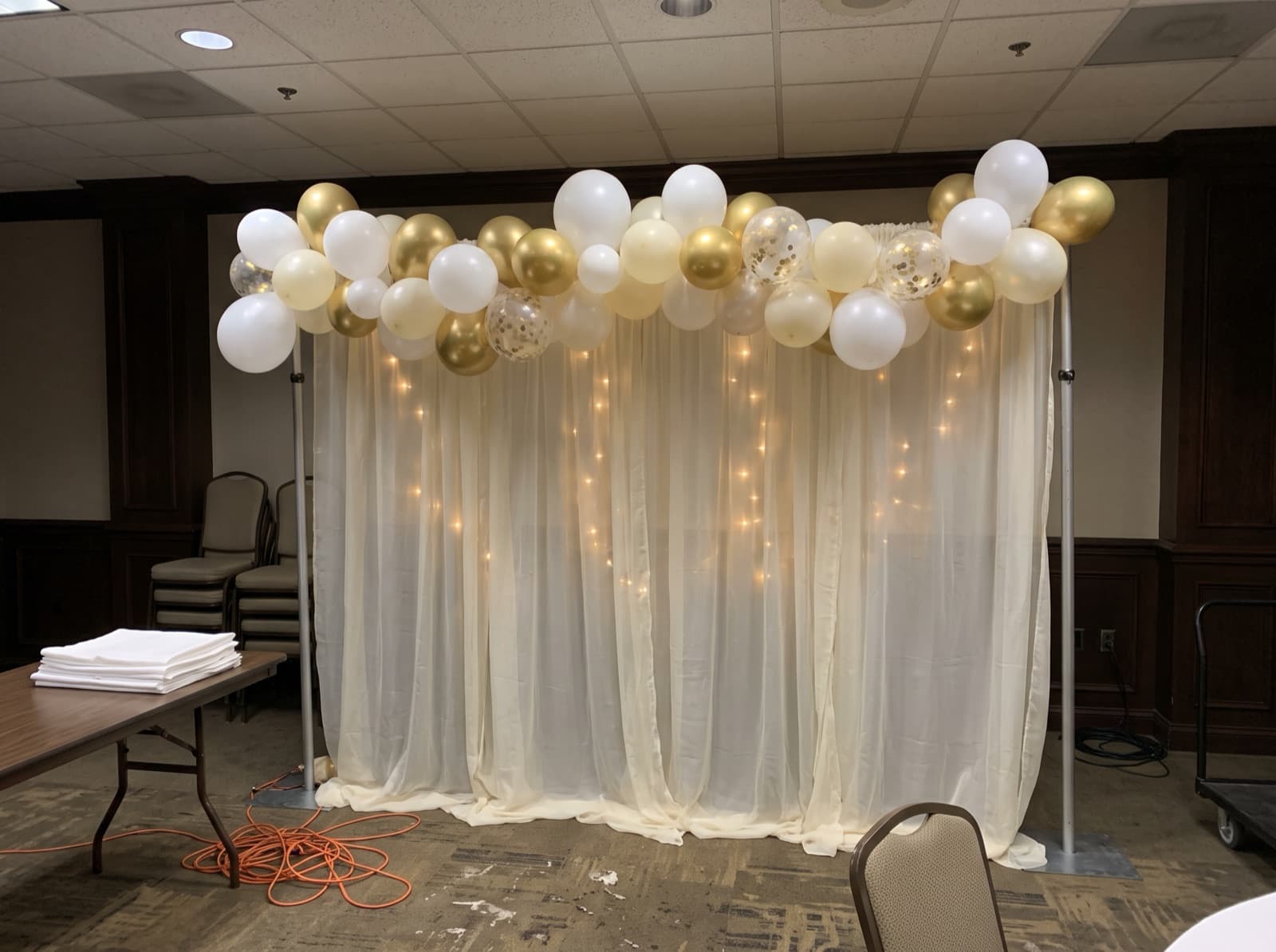 Draped backdrop with balloons and lights