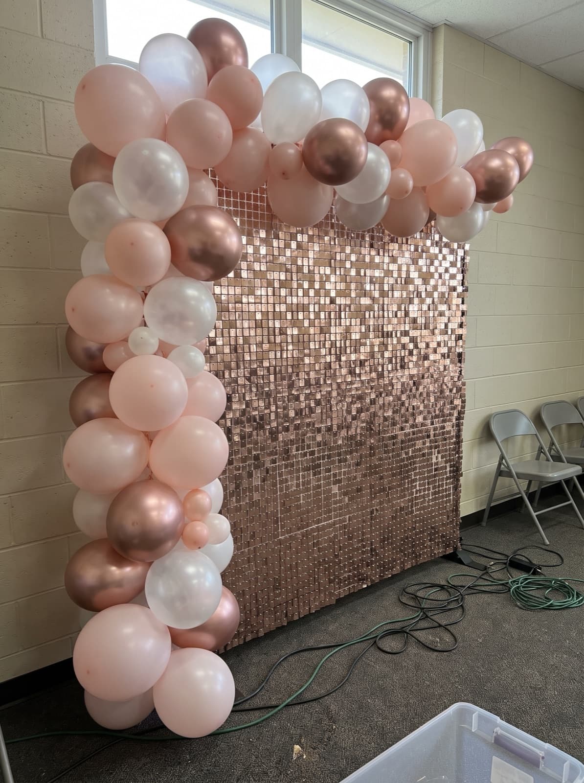 Rose gold sequin wall topped with a blush and white garland