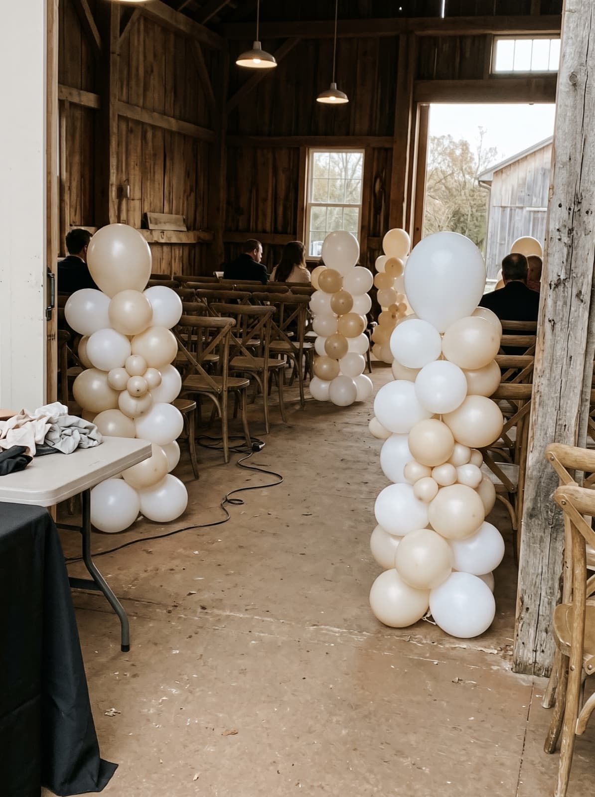 Organic balloon columns lining a wedding aisle