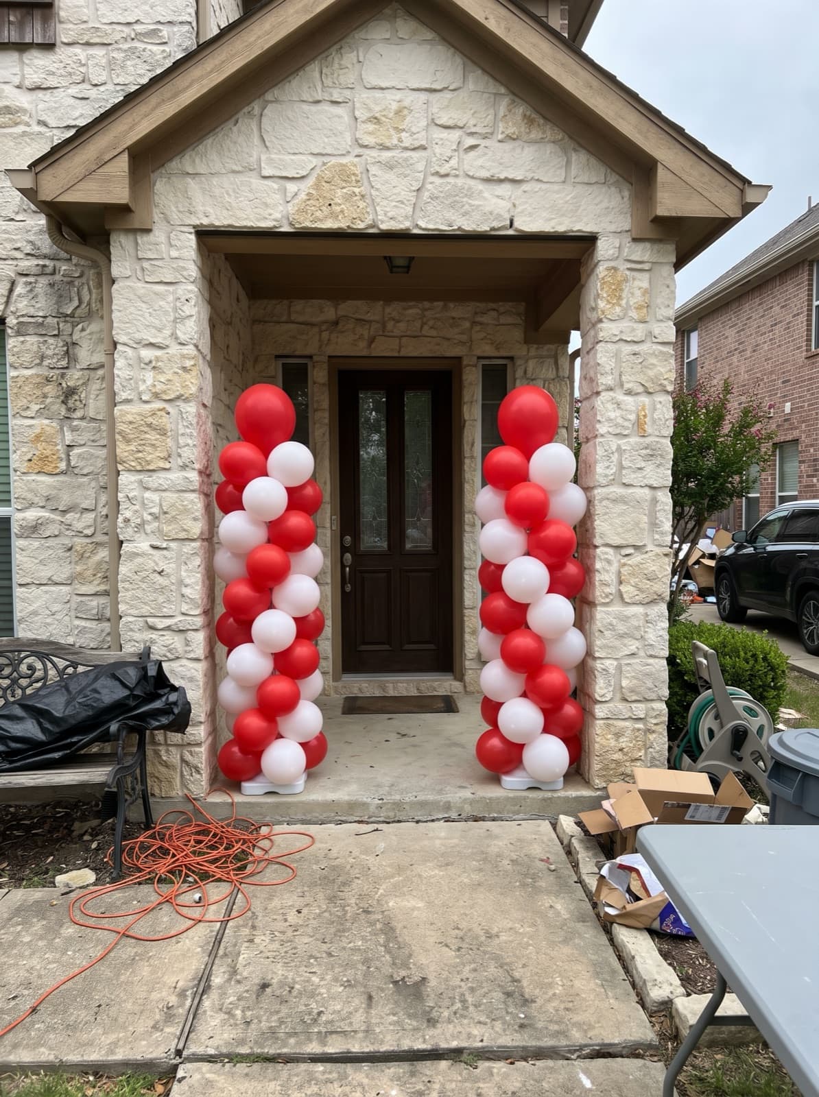 Red and white spiral columns flanking the front door of a stone house