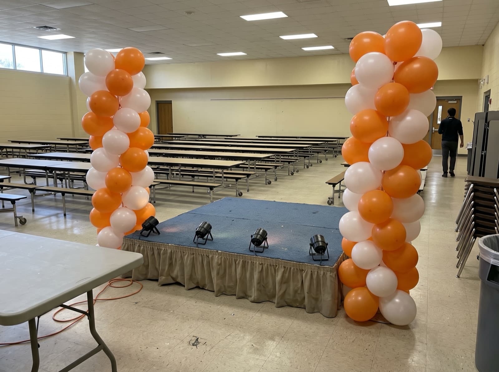 Orange and white columns bookending a school cafeteria stage