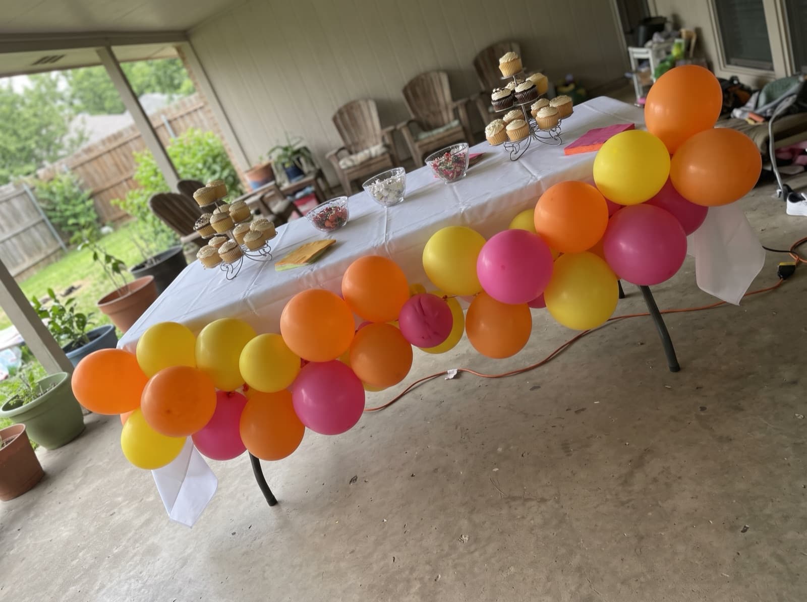 Bright pink, orange and yellow garland along the edge of a cake table