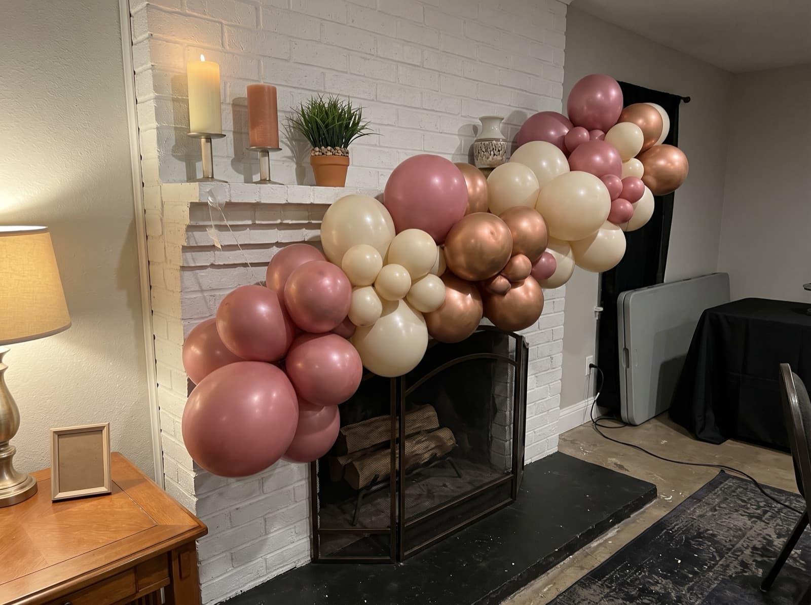 Organic balloon garland in dusty rose, cream and copper along a fireplace mantel in a Dallas home