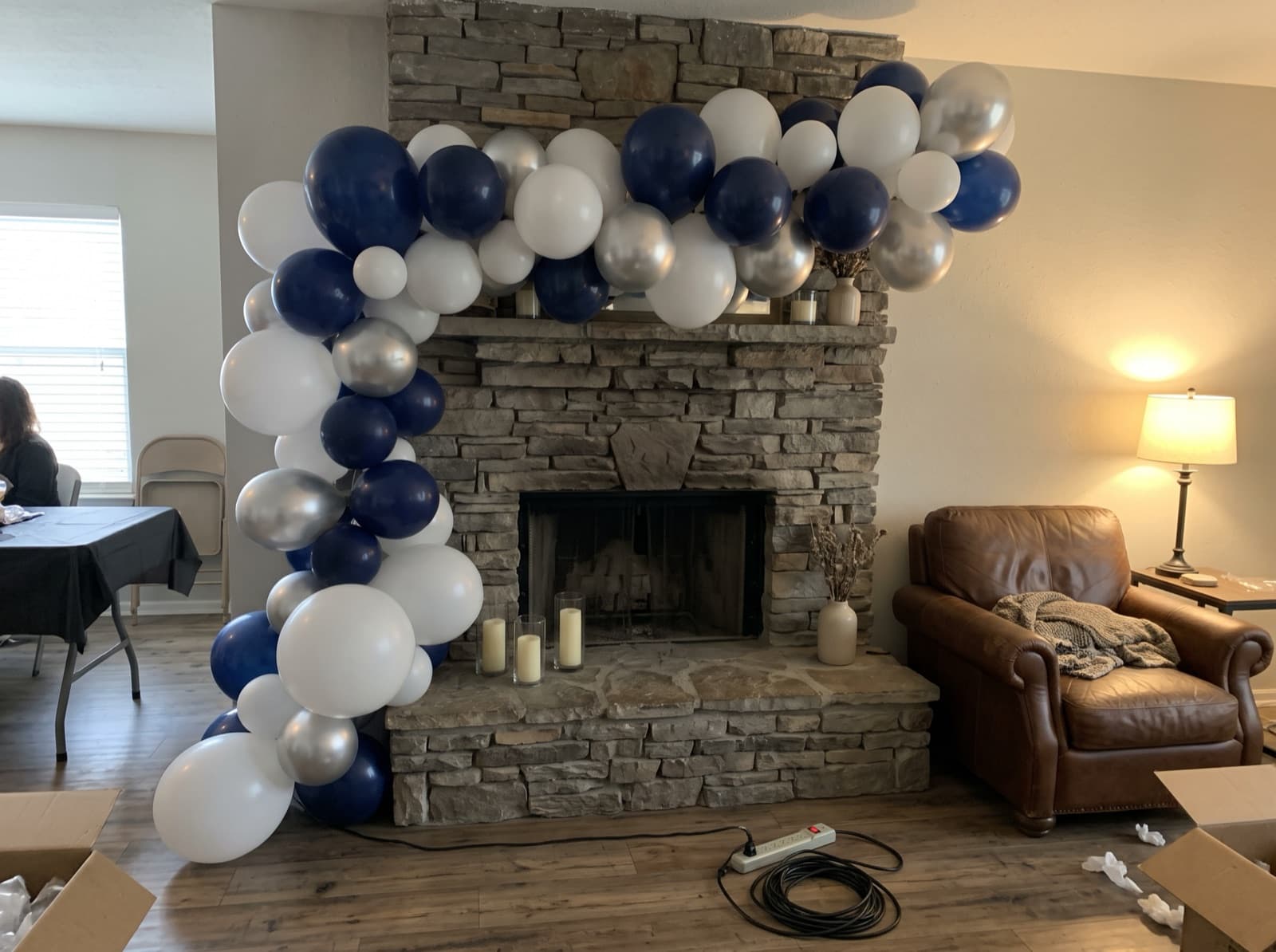 Organic balloon garland along a stone fireplace mantel