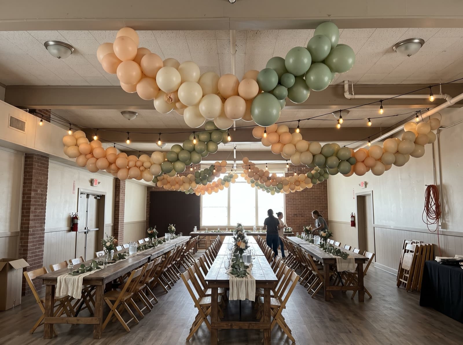 Hanging balloon garland canopy over dining tables