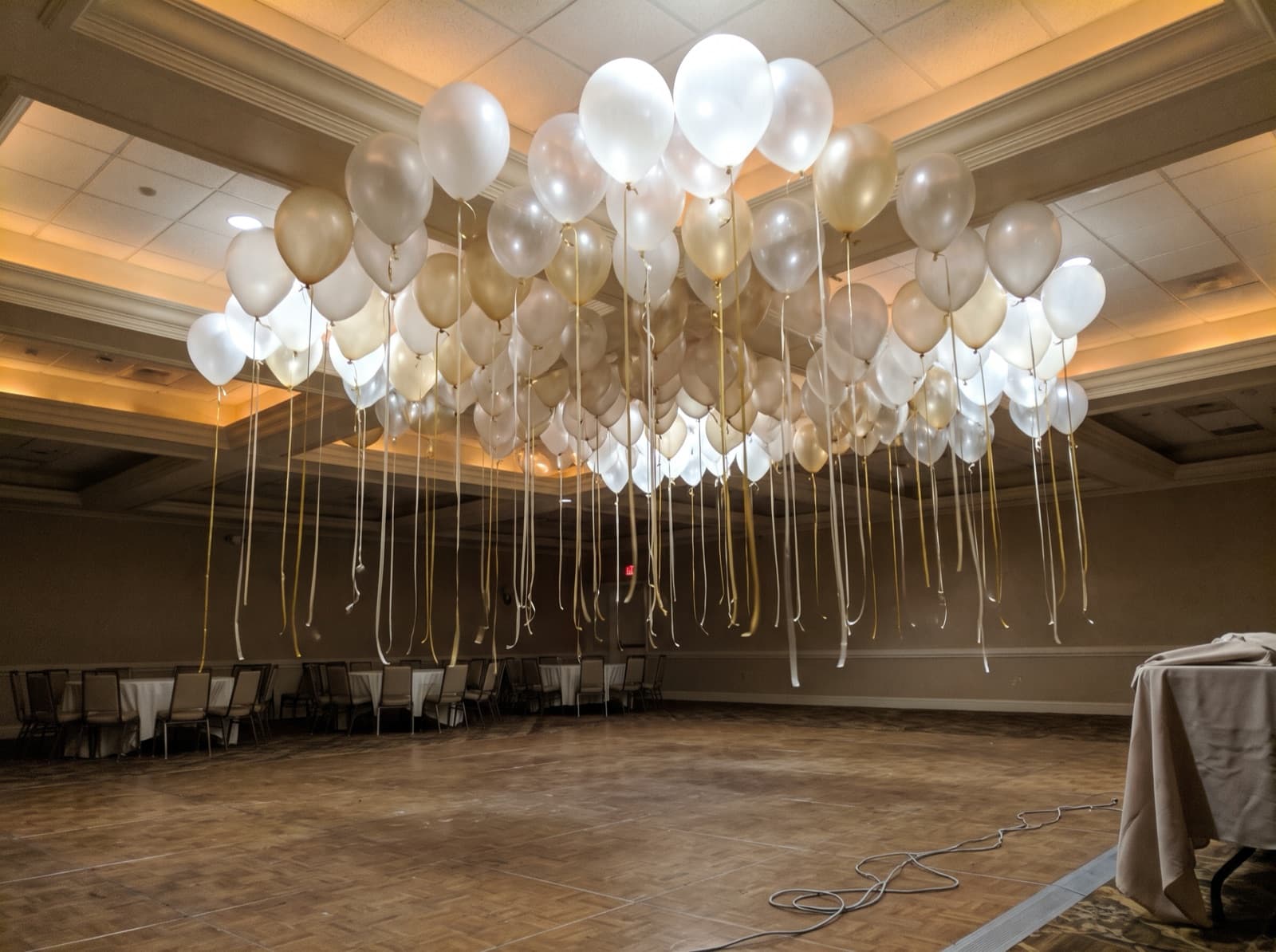 Balloon ceiling of white, clear and champagne balloons over a dance floor in a Dallas hotel ballroom