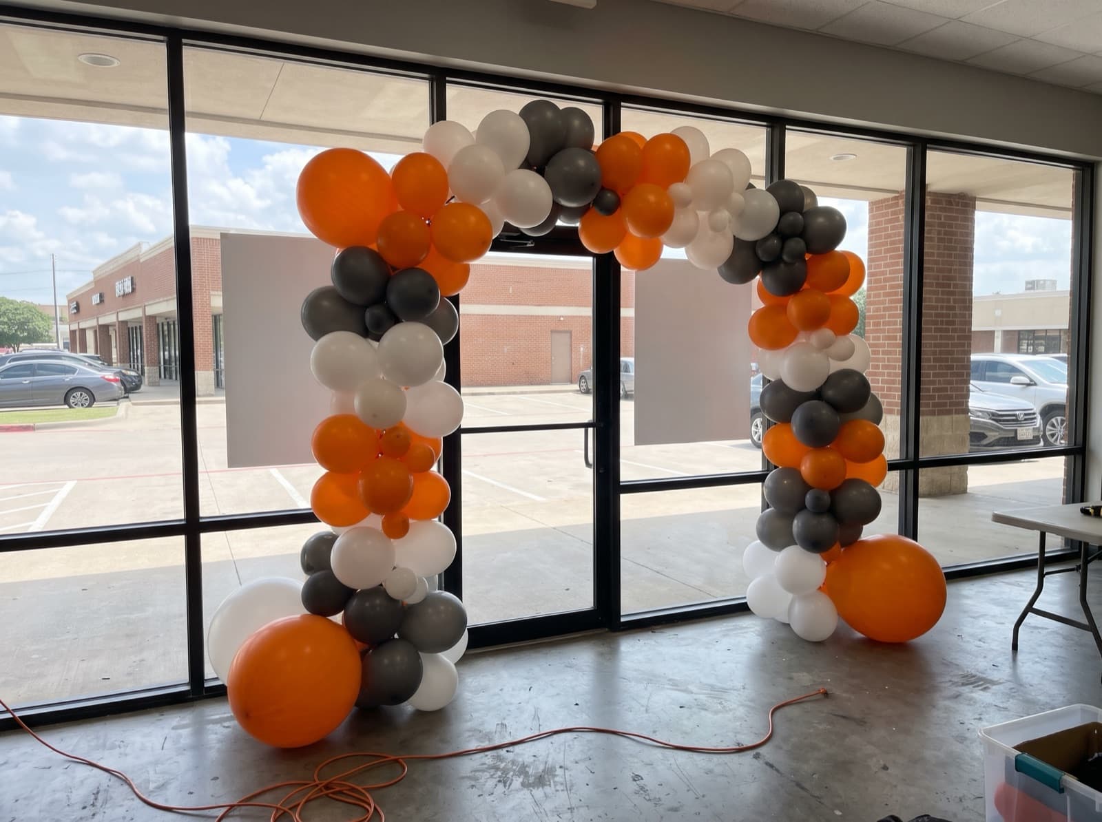 Giant balloon arch installation over a storefront